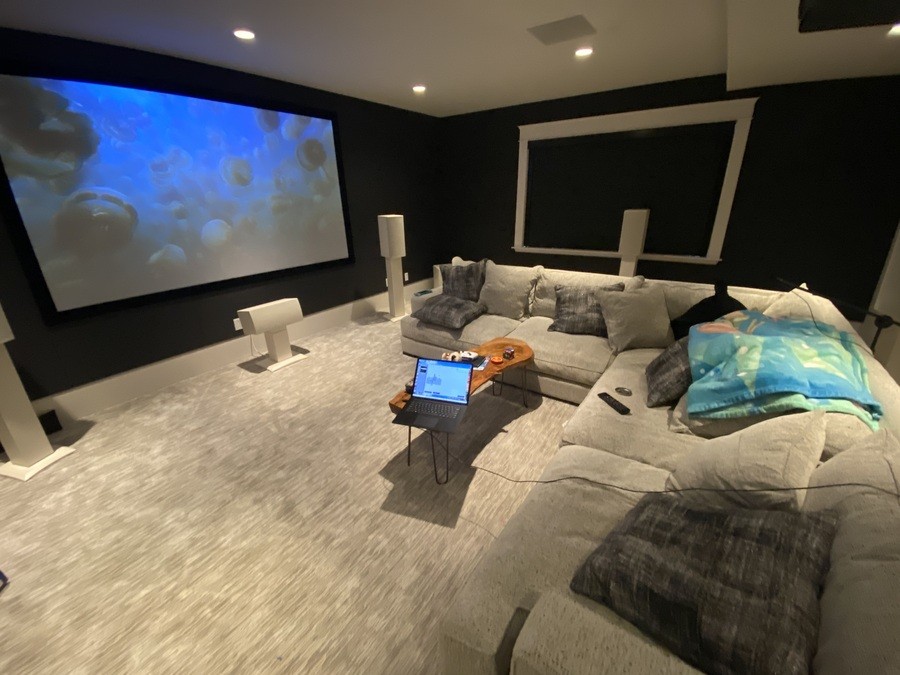 A luxurious home theater with high-quality projection screens and blackout shades.