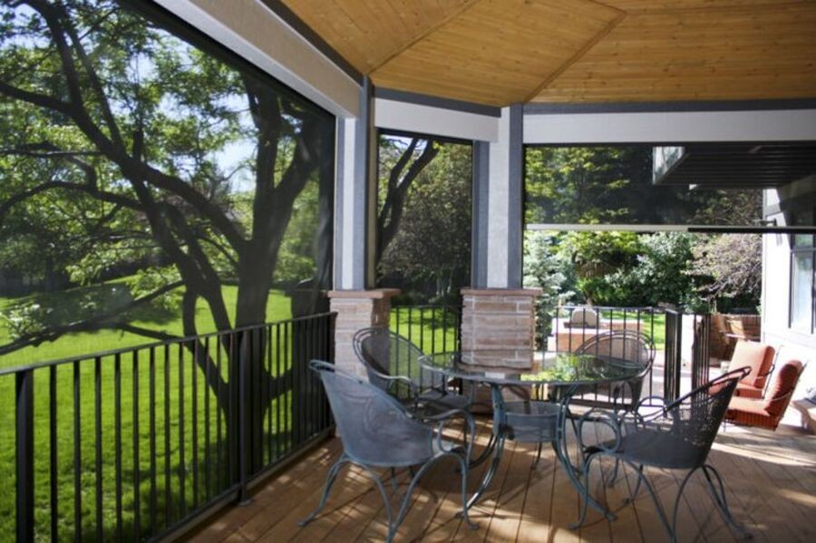 A roofed deck protects the outdoor furniture with Insolroll's outdoor shades.